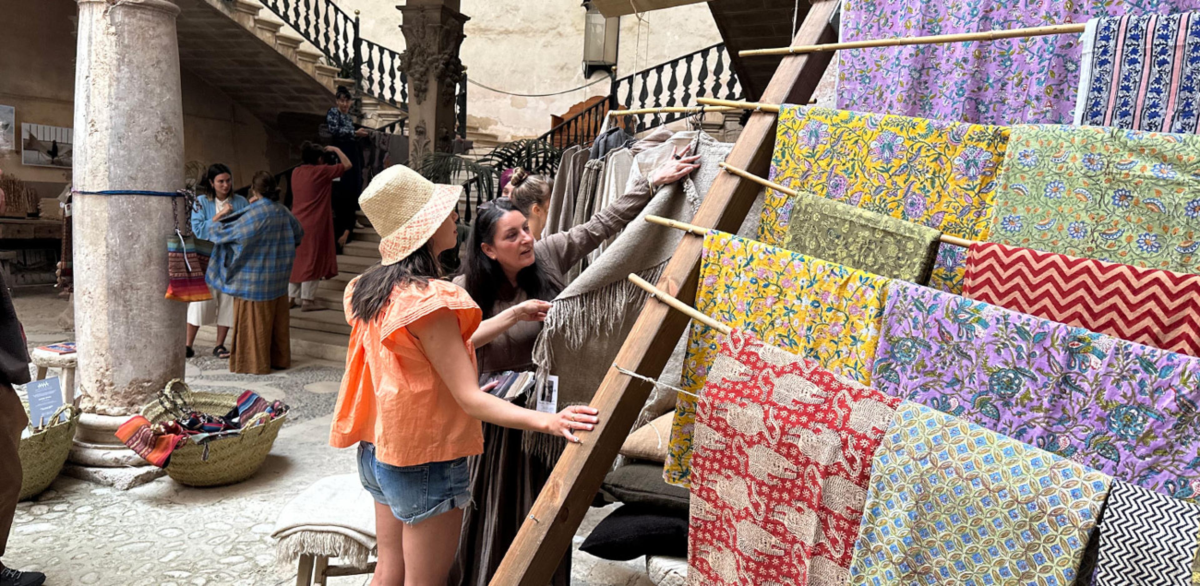 two women look at textile display in historic building 